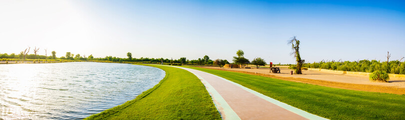 Panoramic view of a lake and grass walkway or track. Love lake Dubai United Arab Emirates.