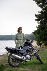 Fototapeta na wymiar girl riding a motorcycle outdoors. Portrait of a confident woman on a beach background