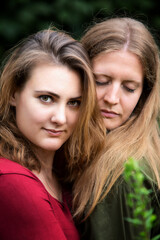 portrait of two young woman hugging outdoors