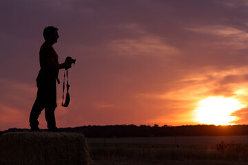silhouette of a man with a photo camera contemplating the sunrise.