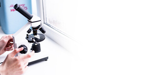 A white microscope on the table, a scientific laboratory. Laboratory of Medical Sciences. Look through a microscope, analyze the test sample. the field of biotechnology, work on advanced equipment