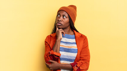 afro black pretty woman with a concentrated look, wondering with a doubtful expression, looking up...