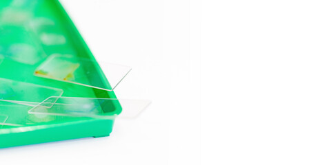 Microscopy and used laboratory glasses for the microscope are on a green tray after the study. results of clinical trials. laboratory studies of drugs, blood and vaccines