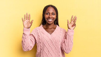 afro black pretty woman smiling and looking friendly, showing number nine or ninth with hand...