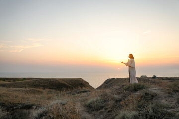 Jesus Christ on hills at sunset. Space for text