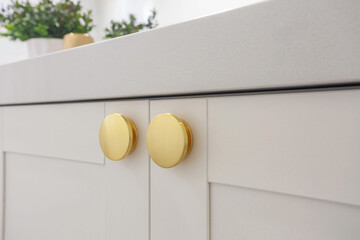 White bathroom counter with round golden handles.