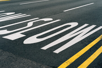 Close-up of traffic warning signs to slow down painted on a asphalt road