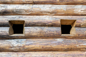 windows in a wooden log wall, an embrasure in a fort