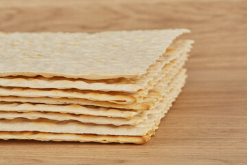 Traditional Jewish matzo lies on a wooden background