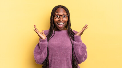 afro black pretty woman looking happy and excited, shocked with an unexpected surprise with both...