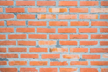 Obraz premium The textures of the orange brick blocks and grey concrete are arranged beautifully and neatly to be the wall