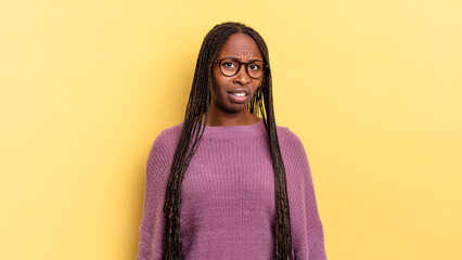 afro black pretty woman feeling puzzled and confused, with a dumb, stunned expression looking at...