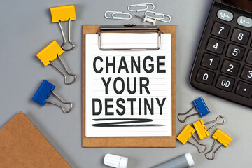 The words Change your destiny written on a white notebook. Work and study concept