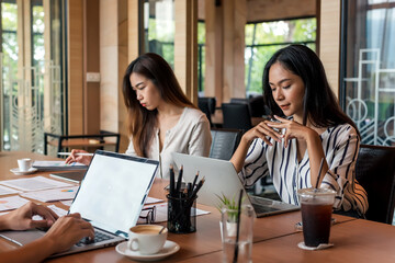 Team business people meeting together brainstorming analyzing discussing to solve problems of the laptop the documents placed at the office.