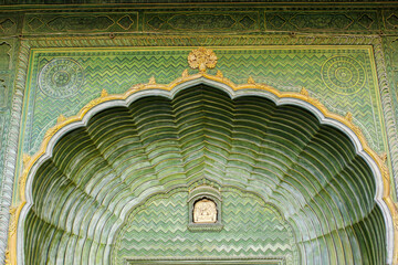 Details on a beautiful green arched doorway with ornate carvings at the ancient City Palace in the...