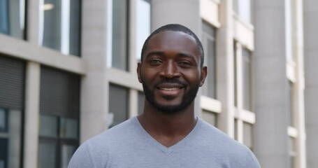 Portrait of happy afro man smiling outdoors during sunny day