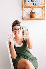 Fototapeta na wymiar Cheerful woman using phone wearing a turbant at home