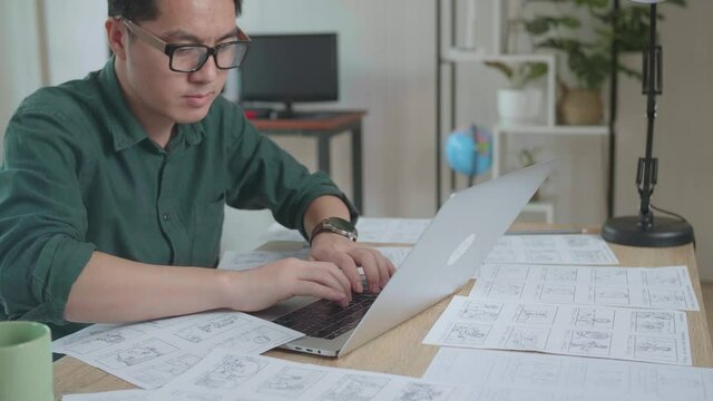 Asian Man Works With Laptop Computer And Storyboard. Video Editing, Comics Compilation, Application Ui Or Game Plot
