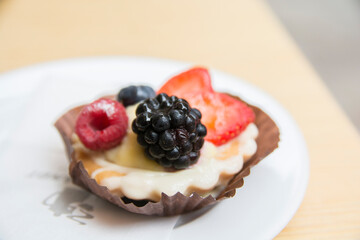 Fruit tartlet, containing strawberries and blackberries and raspberries, served on a plate