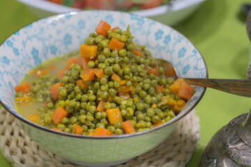 Warm salad of cooked peas and carrots, served in a bowl