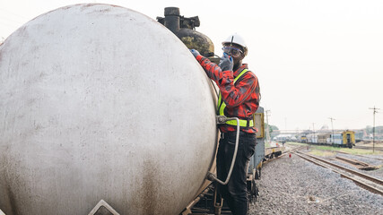 African male engineer control a the train on railway with talking by radio communication or walkie...