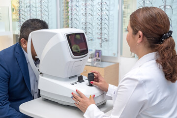 Latino adult with vision problems undergoes an eye exam to evaluate the effects on his cornea. An...