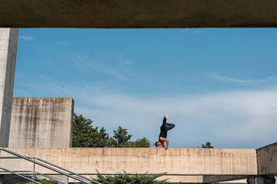 Hip-hop dancer performing a dance pose over rooftop