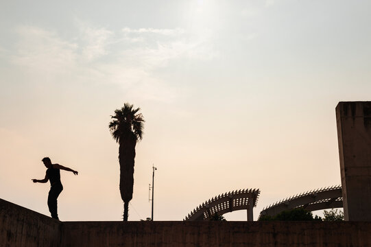 Young break dancer dancing in the street at sunset