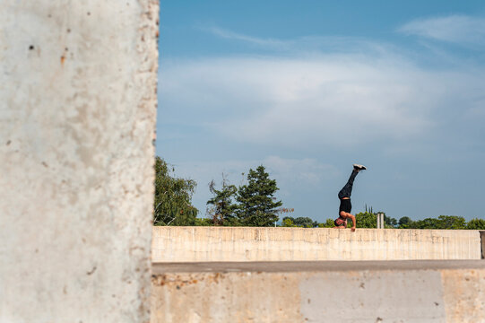 Break dancer performing a hand stand in urban scenery