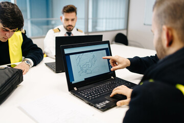 Crop pilots examining map on laptop