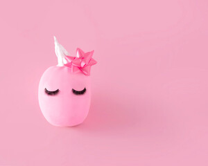 Pink Halloween pumpkin with make up. Minimal Holiday season concept background.