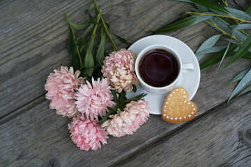 beautiful pink asters, cup of coffee, heart-shaped cookies. romantic breakfast.