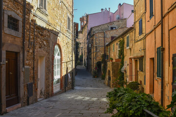 A narrow alley in the old village of Castagneto Carducci in the Maremma area of Tuscany with the typical stone houses, Italy