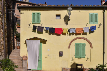Glimpse of the medieval village with washing lines on the façade of an old house in summer,...
