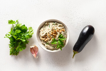 Baba ganoush appetizer made from baked eggplant with parsley, garlic and olive oil on a white...