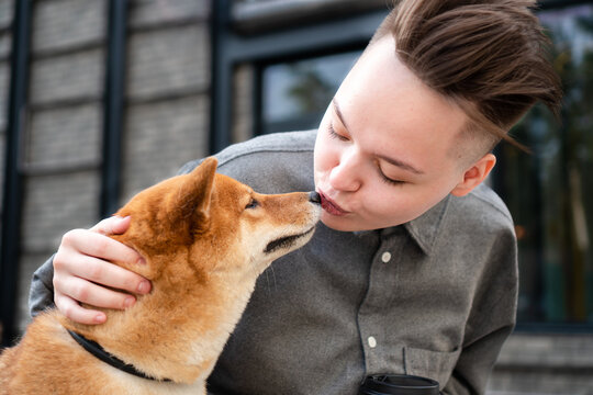Gen z woman kissing dog