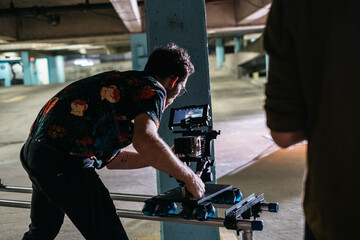 Young cinematographer filming in a parking garage
