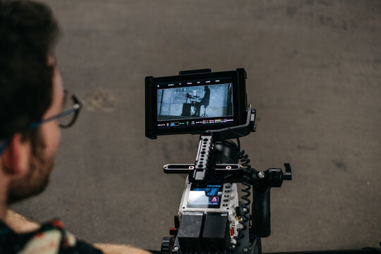 Young cinematographer filming in a parking garage
