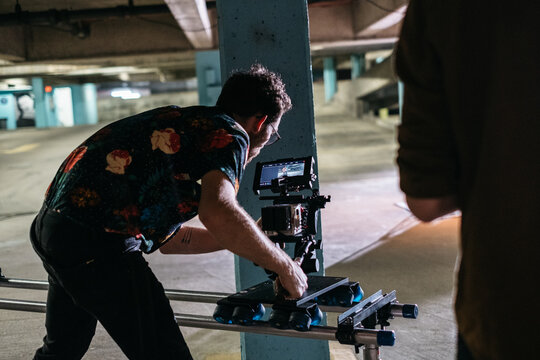 Young cinematographer filming in a parking garage