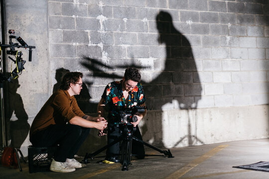 Cinematographer and director filming in a parking garage