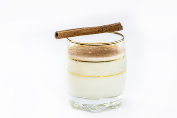 glass of hot eggnog, Christmas drink, made with eggs, cinnamon, almonds and rum liqueur. Isolated white background and copy space.
