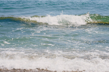 Waves with foam on Aegean sea coast in Crete Greece.