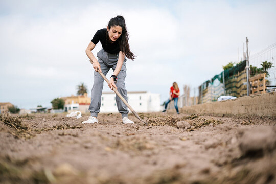Woman digging soil with hoe