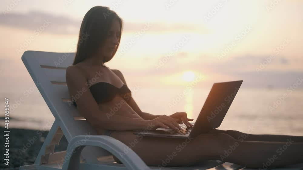 Poster a female freelancer is working on laptop near sea. programmer is coding and surfing on notebook. rem