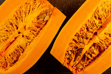 Cutted fresh orange big pumpkin on wooden background, close up. Organic agricultural product,...