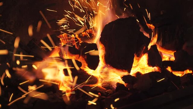 Encendiendo el carb&oacute;n de una barbacoa y saltando chipas al intentarlo