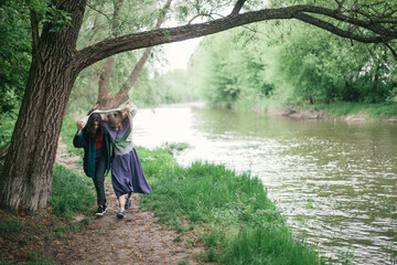 young couple under the trees near the river. 