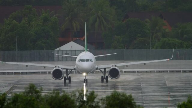 Front view, the plane is taxiing in the rain