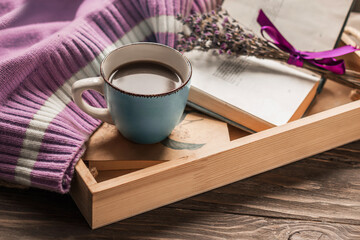 Coffee in bed, romantic morning. Flowers, an open book and a cup of coffee on a wooden tray. Home cozy interior, lifestyle. Selective focus