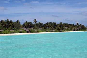 Villas with palm trees on white sandy beach beautiful scenery of Maldives island